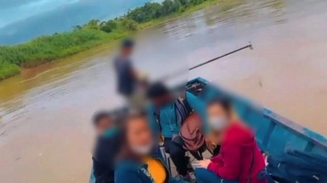 Foto aparat Thailand dan korban orang India menyeberangi sungai.