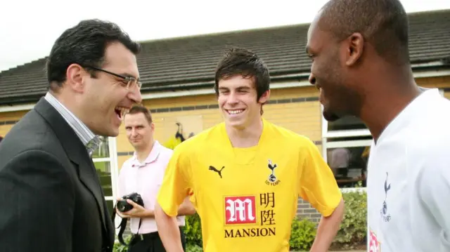 دامیان کومولی، مدیر وقت فوتبال باشگاه تاتنهام، در حال شوخی با خریدهای جدید این تیم، گرث بیل و دارن بنت، در ژوئیه ۲۰۰۷ 