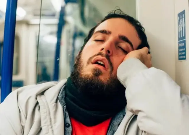 Un homme barbu qui dort