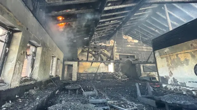 Так отель выглядел изнутри с утра, когда спасательные работы еще продолжались. На фото видно выгоревшее помещение, по всей видимости, на верхнем этаже. Часть скошенного потолка еще горит.