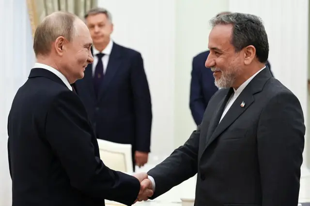 Presiden Rusia Vladimir Putin dan Menteri Luar Negeri Iran Abbas Araghchi berjabat tangan dalam pertemuan di Kremlin di Moskow pada tanggal 23 Juni 2025.