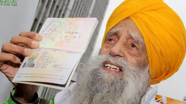 Фауджа Сінгх показує свій британський паспорт, щоби довести свій вік. Фото 2013 року