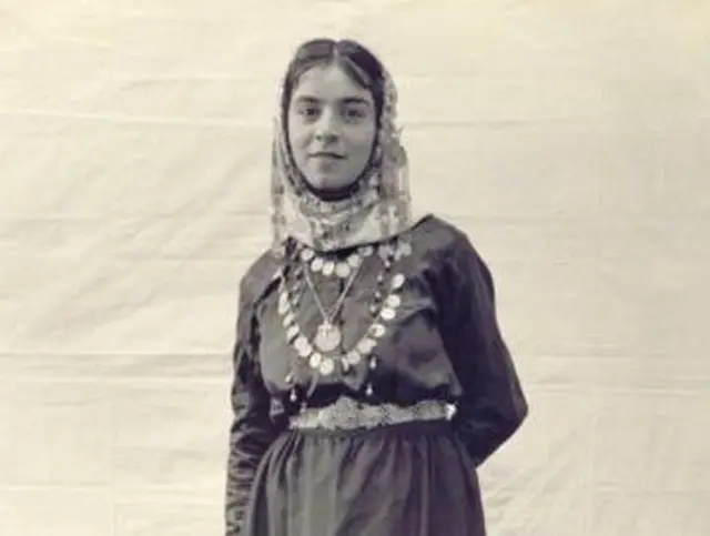 Старе чорно-біле фото дівчини у національному костюмі, у неї на голові хустка, на шиї намисто