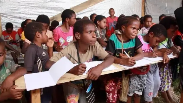 Anak-anak terpaksa berhimpitan satu sama lain ketika belajar di sekolah darurat di Wamena, akibat konflik bersenjata di Nduga.