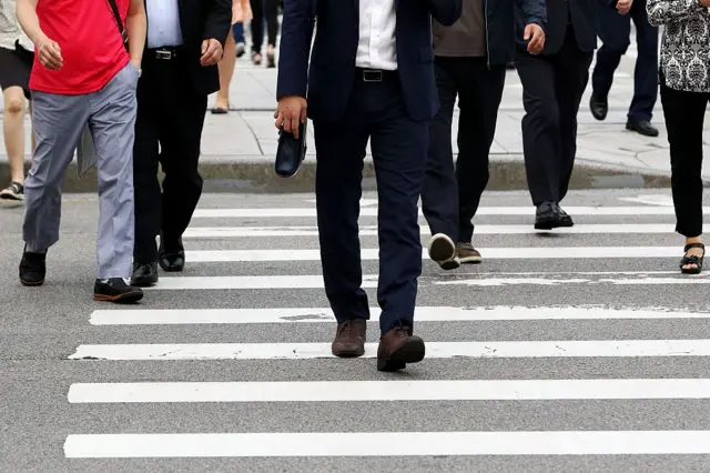 서울의 한 건널목을 건너는 정장 입은 사람