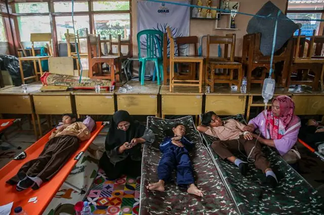 Siswa beristirahat di tempat tidur portabel saat mereka menerima perawatan karena keracunan makanan setelah mengonsumsi makanan sekolah gratis yang disubsidi pemerintah di SMPN 1 Cisarua di Kabupaten Bandung Barat, Jawa Barat, Indonesia, pada 15 Oktober 2025.
