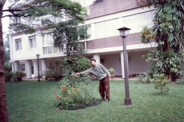 Tom Zé mostrando flores em jardim do prédio onde morava