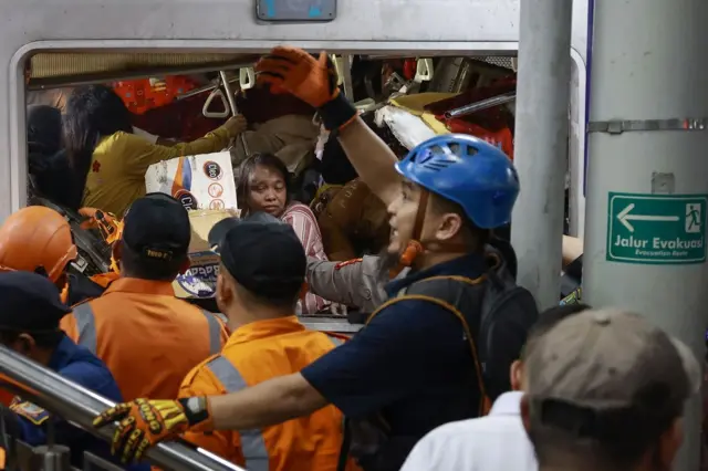 Petugas mengevakuasi korban yang masih terjebak di dalam gerbong KRL Commuterline 