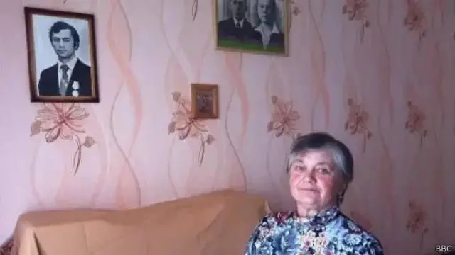 Наталія Ходимчук біля потрета чоловіка Валерія