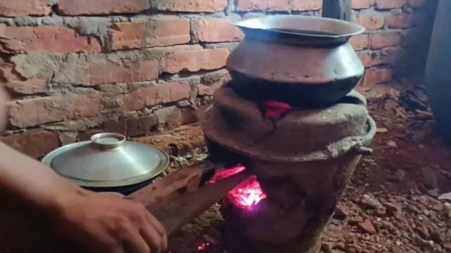 গ্যাস না থাকায় মাটির চুলায় কাঠ দিয়ে রান্না করেছেন অনেকে