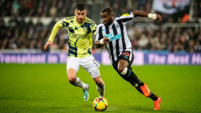 Marc Roca, pemain untuk Leeds United, bermain melawan Allan Saint-Maximin dari Newcastle United. Keduanya mengenakan kaus yang disponsori perusahaan ‘merek putih’ seperti SBOTOP dan Fun88.