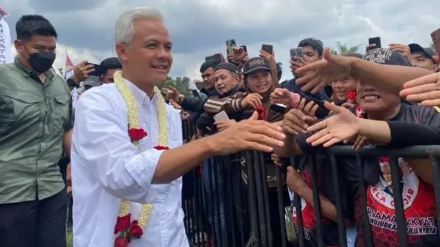 Calon presiden (capres) nomor urut 3 Ganjar Pranowo menyalami pendukungnya yang menghadiri kampanye akbar bertajuk Hajatan Rakyat di Istana Maimum, Medan, Sumatera Utara, Minggu (28/1)