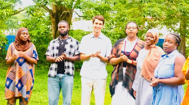 Àwọn akẹ́kọ̀ọ́ tí wọ́n ń kọ́ nípa èdè Yorùbá mẹ́fà tí wọ́n dúró tí wọ́n sì ń wo ọ̀ọ́kan láti ya àwòrán