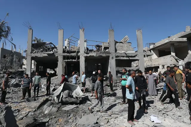 Deyr el Belah'ta 29 Mayıs'ta Bureyc Mülteci Kampı'na İsrail saldırısı sonrası yıkılan binaların etrafını çevrelemiş Gazzeliler