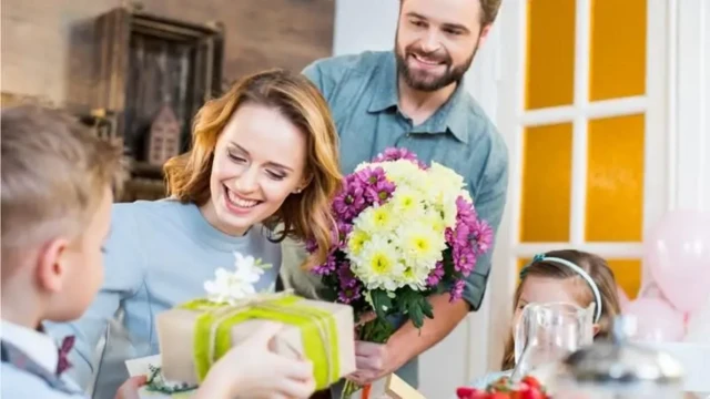 مردی و دو کودک در حال هدیه دادن به یک زن