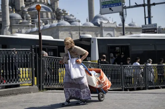 pazar arabası çeken yaşlı bir kadın