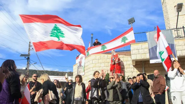 يرفع الناس الأعلام ويرقصون احتفالاً بانتخاب جوزيف عون، وهو من أبناء قريتهم، رئيساً للبنان، في بلدة العيشية الجنوبية في 9 يناير/كانون الثاني 2025. 