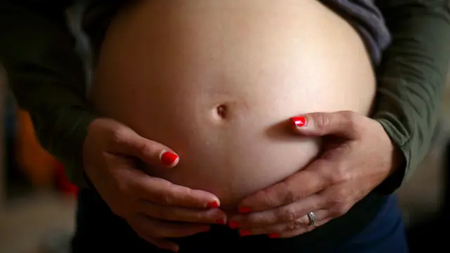 Imagen de una mujer mostrando su embarazo.