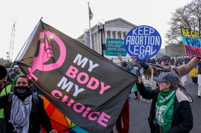 Demonstrators hold up signs during a protest in front of the Supreme Court during the "Bans Off Our Mifepristone" action organized by the Woman's March outside of the Supreme Court on March 26, 2024 in Washington DC