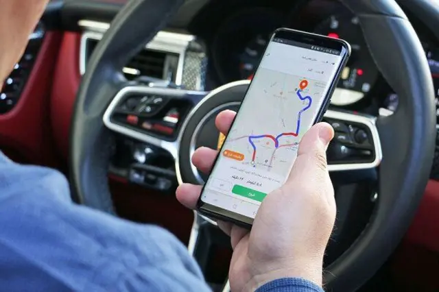 راننده در حال استفاده از اپلیکیشن‌های مسیریابی