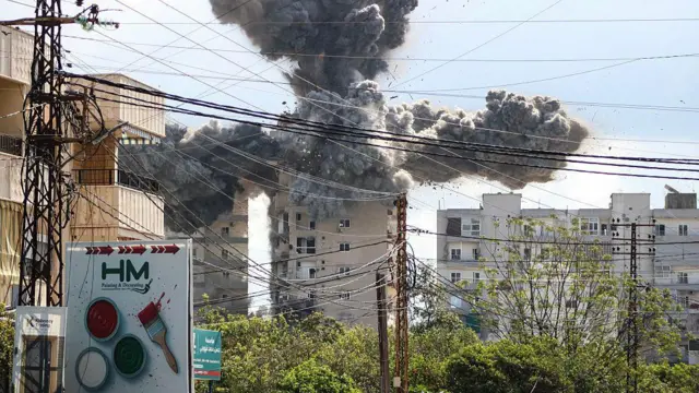 Дым и обломки поднимаются в воздух после израильского авиаудара в районе Аббасие, на окраине города Тир, 8 апреля 2026 года