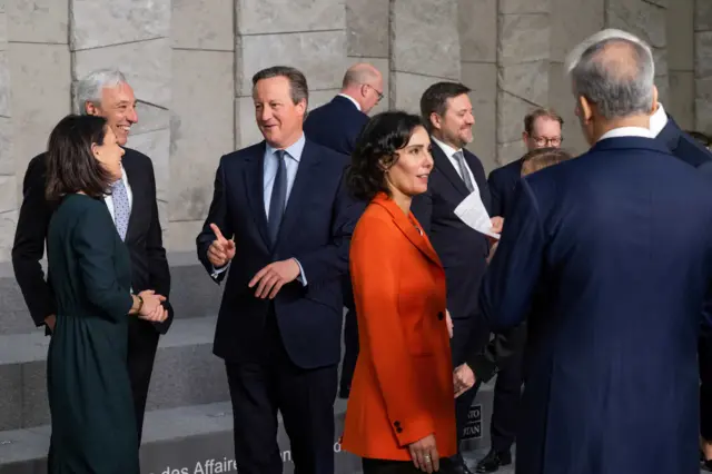 ဘယ်လ်ဂျီယံနိုင်ငံ မြို့တော် ဘရက်ဆဲလ်မြို့မှာ နေတိုးနိုင်ငံခြားရေးဝန်ကြီးတွေအစည်းအဝေးမှာ စကားပြောနေတဲ့ ဗြိတိသျှ နိုင်ငံခြားရေးဝန်ကြီး ဒေးဗစ် ကင်မရွန်း( ဘယ်ဘက်ဒုတိယမြောက်အမျိုးသား)နဲ့ ဂျာမနီနိုင်ငံခြားရေးဝန်ကြီး