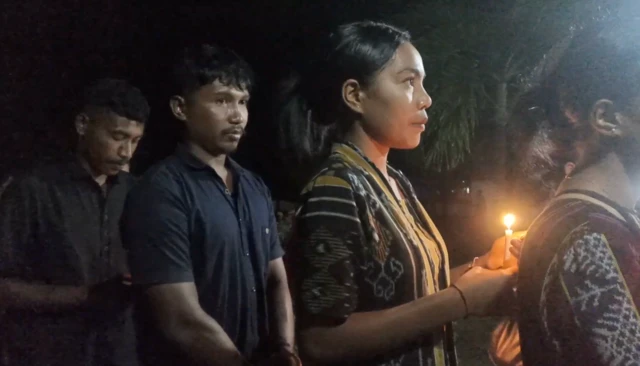 Usai misa, umat Katolik di Maumere berjalan sambil membawa lilin dan berdoa di depan foto Paus Fransiskus.