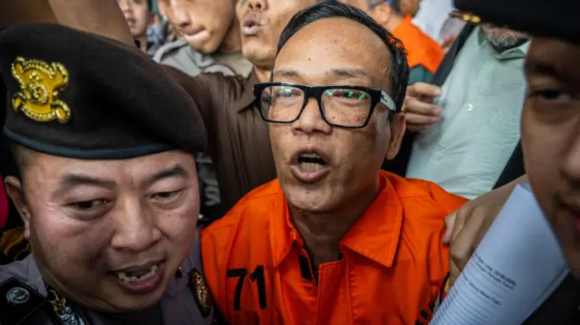 Immanuel Wakil Menteri Ketenagakerjaan (Wamenaker) Immanuel Ebenezer (tengah) berjalan menuju mobil tahanan usai dihadirkan sebagai tersangka saat konferensi pers di kantor KPK, Jakarta, Jumat (22/08/2025).