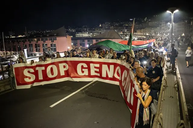 30 Ağustos'ta Cenova'da yapılan yürüyüşte "Soykırımı Durdurun" pankartı arkasında karanlıkta yürüyen çok sayıda gösterici Filistin bayrağı taşıyor