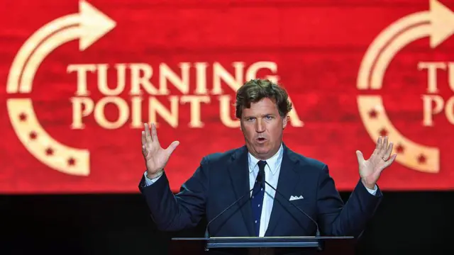 تاكر كارلسون متحدثاً خلال فعالية تأبين الناشط السياسي تشارلز كيرك الشهر الماضي