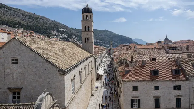 Вулиця в Дубровнику, вид згори, будинки з черепичними дахами, на задньому плані гори