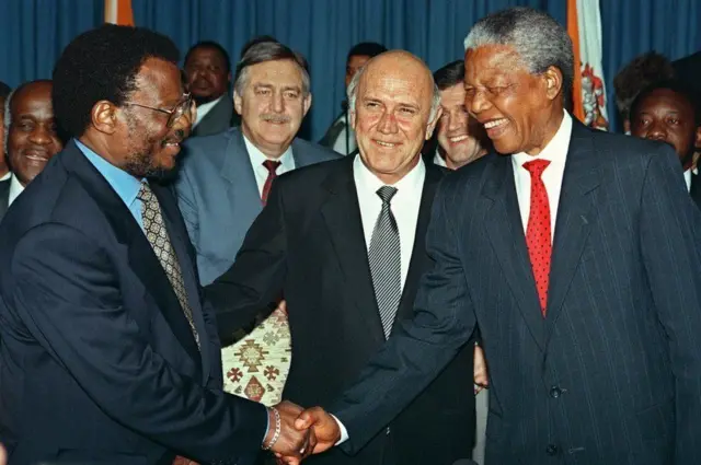 Umutware Buthelezi (i bubamfu) aramukanya n'umukuru wa ANC  Nelson Mandela (i buryo) bahagarikiwe na Perezida FW De Klerk wa Afrika y'Epfo mu 1994