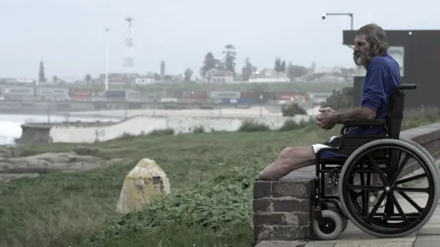 Louis van Schoor dans son fauteuil roulant près d'un fleuve