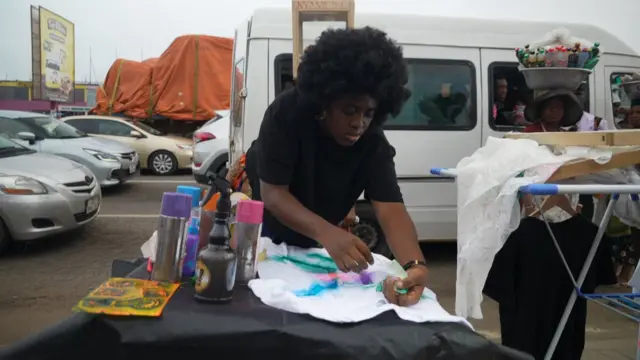 Habarata as she dey design her cloth for road 