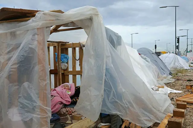A displaced baby sleeps inside a tent at a parking lot in Beirut's waterfront area, on March 22, 2026. 