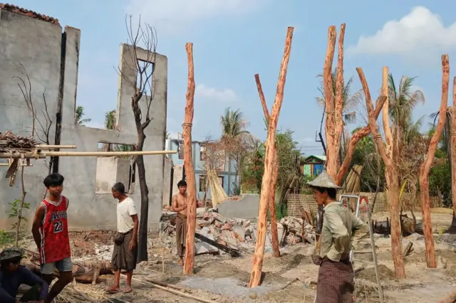 May 21, 2024 shows people rebuilding temporary homes near a destroyed building following fighting between Myanmar's military and the Arakan Army (AA) ethnic minority armed group in a village in Minbya Township in western Rakhine State.