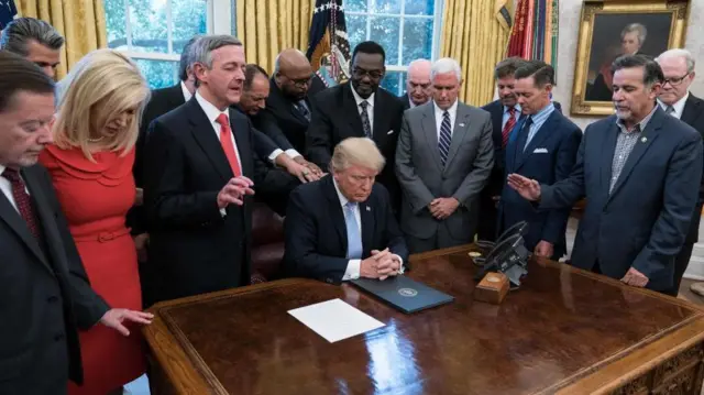 US President Donald Trump and religious leaders pray in the Oval Office of the White House, in September 2017