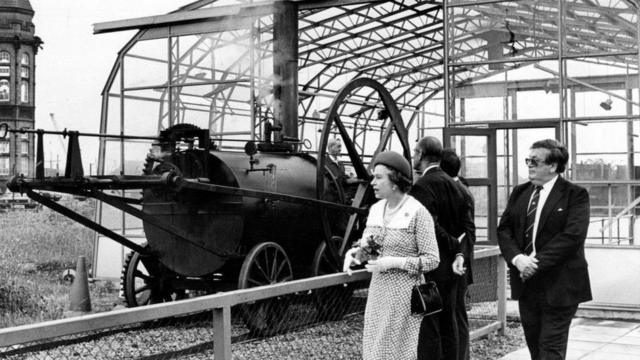 La reina Isabel III viendo la replica de la primera locomotora.