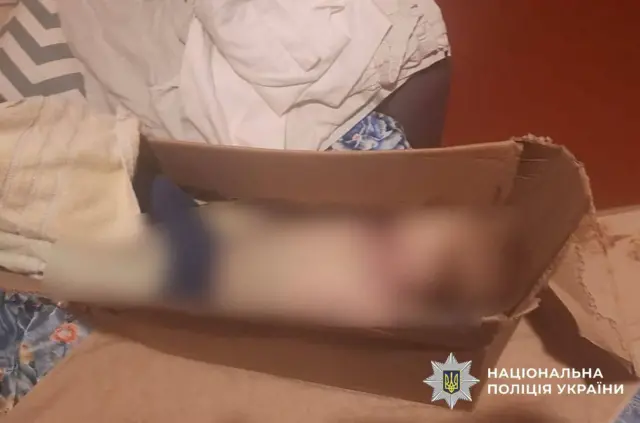 заблюрене тіло мертвої дитини в коробці