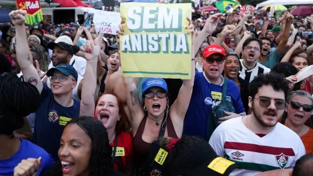 Manifestantes seguram cartaz escrito "sem anistia" no Rio de Janeiro. 