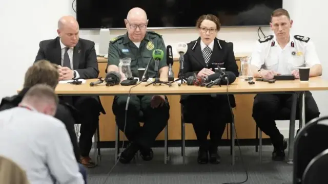 記者会見を開くイングランド北西部の救急サービスのデイヴィッド・キッチン氏（中央左）、マージーサイド消防救助サービスのニック・サール署長（右）ら（26日）