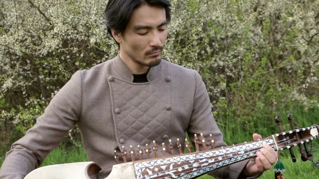 سایتو در حال رباب نواختن در فضای سبز