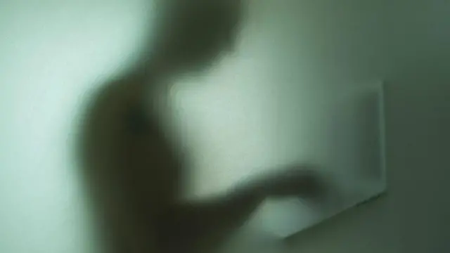 ظل شخص يمسك بـ لابتوب