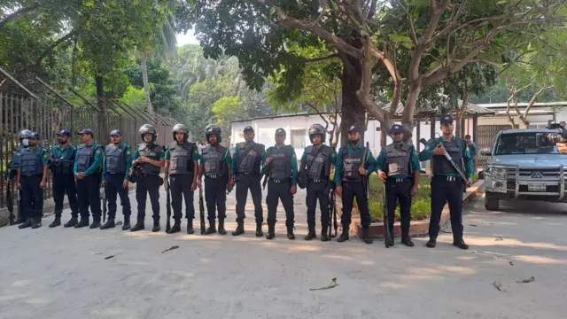 একদল পুলিশ দাঁড়িয়ে আছে