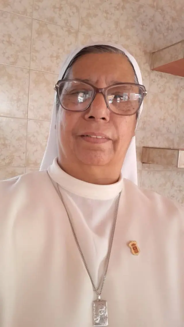 La hermana mercedaria Neyda Rojas con lentes, el hábito blanco y una cadena plateada con una pequeña placa.