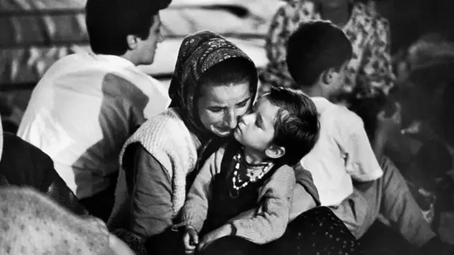 Евакуйована зі Сребрениці до табору біженців жінка з дитиною оплакує свого чоловіка після повідомлення про масові вбивства