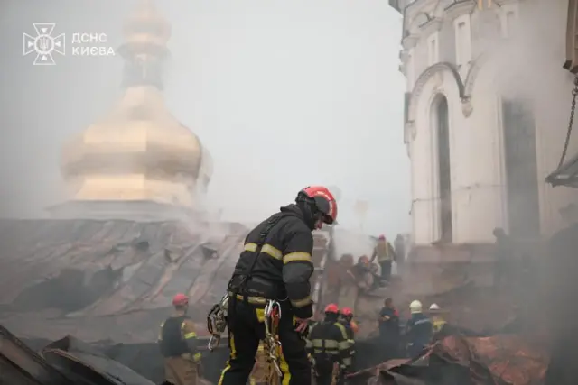 Пожарные тушат пожар на крыше, рядом видна часть золотого купола