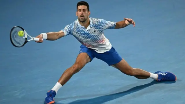 جوکوویچ در حالی که به بدنش کش داده است که یکی از ضربات معروف خود را، این بار در اوپن استرالیا، می‌زند