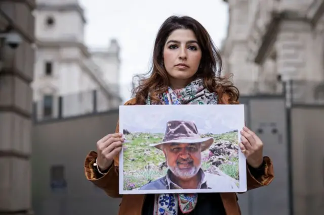 La fille de Tahbaz tient sa photo devant le ministère britannique des Affaires étrangères à Londres