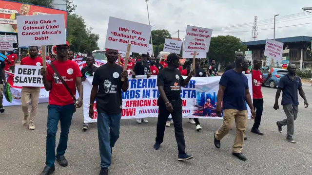 Some men carry placards dey waka